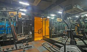 a gym with several tread machines and a mirror at Dee Empresa Hotel in Kolkata