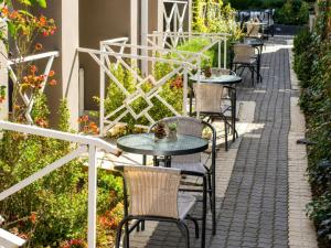 a row of tables and chairs on a patio at Comfort e Casa Lodge Near OR Tambo Airport in Kempton Park