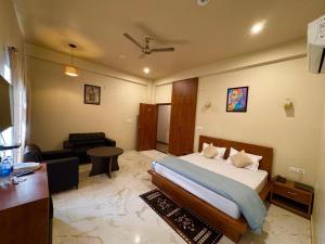 a bedroom with a bed and a living room at Green hillock hotel in Alwar