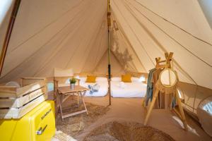 a room with a tent with a bed and a table at Kampaoh Praia do Meco in Sesimbra