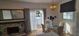 a living room with a table and a fireplace at Elegant White Cottage in Bomaderry