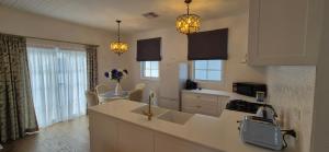 a kitchen with a sink and a counter top at Elegant White Cottage in Bomaderry