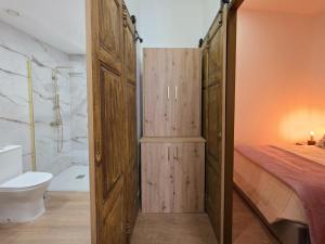 a bedroom with a wooden door and a bed and a toilet at Monção Golden I I in Monção
