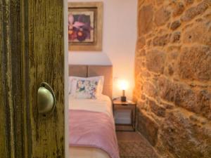a bedroom with a bed and a stone wall at Monção Golden I I in Monção