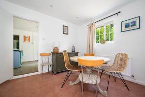 a dining room with a table and chairs at The Cottage at Cobbolds Mill in Monks Eleigh