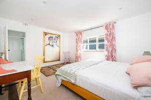 a bedroom with a bed and a desk and a window at The Cottage at Cobbolds Mill in Monks Eleigh
