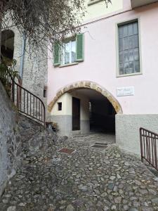 an entrance to a pink building with an archway at ALBERGO DIFFUSO ORNICA NEL CUORE in Ornica