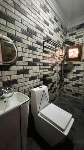 ein Badezimmer mit weißer Toilette und Waschbecken in der Unterkunft Résidence AELA in Banfora