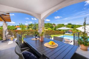 a patio with a blue table with a bowl of fruit on it at Villa Bartol in Trviž