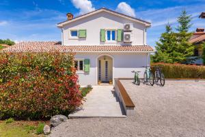 a white house with two bikes parked in front of it at Villa Bartol in Trviž