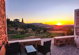 a sunset from a patio with a table and chairs at Tsitsinos Village Cottage in Zekros