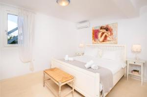 a white bedroom with a white bed and a table at Lunar Villa in Glastros