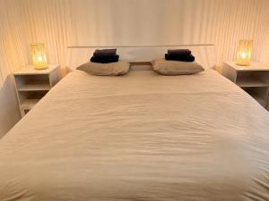 a large white bed with two lamps on two tables at Downtown Velvet Loft in Brussels