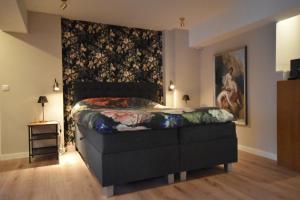a bedroom with a bed with a painting on the wall at De Vechthoeve in Dalfsen