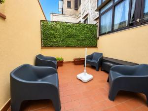 a patio with black chairs and a green hedge at Anastasia's House in Palermo