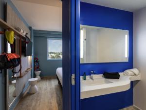 a bathroom with a white sink and a blue wall at ibis budget Aguascalientes Norte in Aguascalientes +35 photos