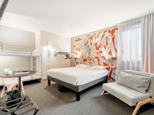 a bedroom with a bed and a desk and a chair at Ibis Styles Toulouse Centre Canal du Midi in Toulouse +95 photos