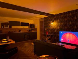 a living room with a couch and a television at Le fruit défendu 67 in Brumath +15 photos