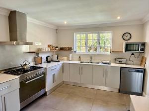 a large kitchen with white cabinets and a window at Anesta House in Stellenbosch