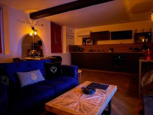 a living room with a blue couch and a table at Le fruit défendu 67 in Brumath