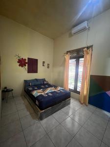 a bedroom with a bed and a window at Family Hostel Lovina in Lovina