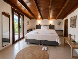 a bedroom with a large bed and a large window at Aliston Hotel Thassos in Skala Potamias