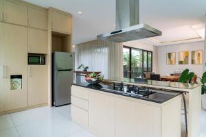a kitchen with a stove and a refrigerator at Oyama City View Villa 4 Bedrooms With a Private Heated Swimming Pool and a Billiard Table in Bandung