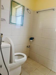 a bathroom with a toilet and a mirror at Kattel HomeStay And Apartments in Bālāju