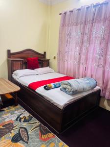 a bedroom with a bed with a wooden frame and a window at Kattel HomeStay And Apartments in Bālāju +15 photos