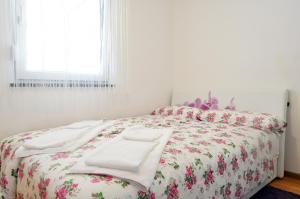 a bedroom with a bed with a floral bedspread at Lavanda Haus in Vodnjan