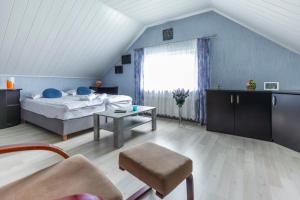 a bedroom with a bed and a table and a window at Dom przy plaży in Giewartów