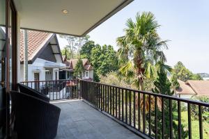 a balcony with a view of a palm tree at Oyama City View Villa 4 Bedrooms With a Private Heated Swimming Pool and a Billiard Table in Bandung