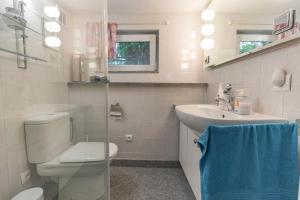 a white bathroom with a toilet and a sink at Dom przy plaży in Giewartów +69 photos