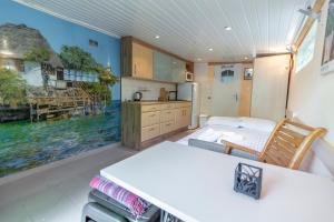 a bedroom with a kitchen with a painting on the wall at Dom przy plaży in Giewartów
