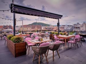 a restaurant with pink chairs and tables on a roof at Hotel Memories OldTown in Budapest