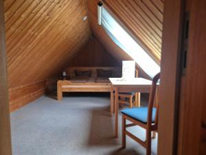 a room with a bed and a table in a attic at Speck 5 klein in Kargow