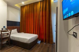 a hotel room with a bed and a television at Grand Hotel Annex in Āīzawl