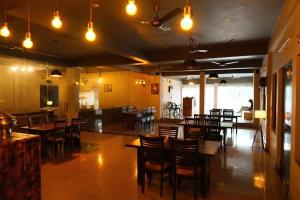 a restaurant with wooden tables and chairs and lights at Green hillock hotel in Alwar +9 photos