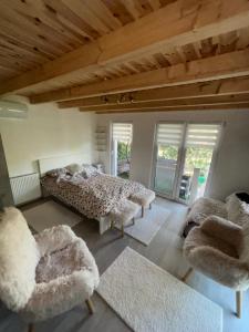 a bedroom with two beds and two chairs at Pop Apartment Kerepes in Kerepes