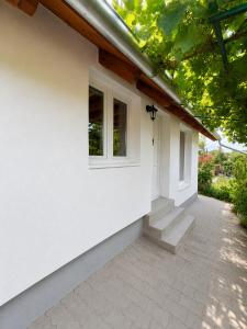 a white house with stairs and a window at Pop Apartment Kerepes in Kerepes