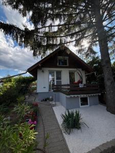a small white house with a porch and a tree at Pop Apartment Kerepes in Kerepes