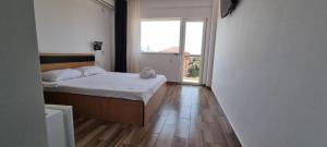 a bedroom with a bed and a large window at Blue Sky Hotel in Eforie Nord