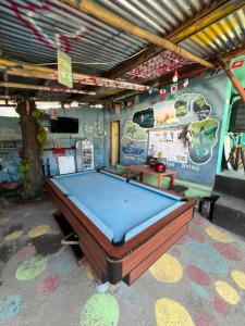 a pool table sitting in a room with avertisement at Family Hostel Lovina in Lovina