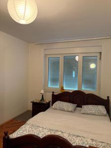 a bedroom with a large bed and two windows at Una Mirage in Bihać
