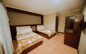 a hotel room with two beds and a television at Grotto Vista Resort in San Jose del Monte