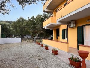 a house with a row of potted plants next to it at Residence Il Pantheon - Fuscaldoapartment in Marina di Fuscaldo