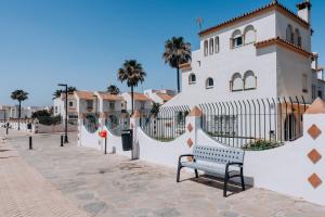 a bench in front of a building with a fence at Casa Mar & Golf in San Luis de Sabinillas