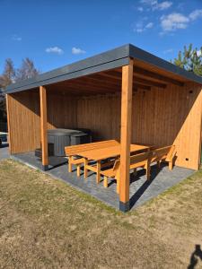 a wooden pavilion with a picnic table and a grill at Cudowne domki in Ostrzyce +8 photos