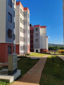 a row of tall buildings with a sidewalk in front at The Crown Stay in Machakos