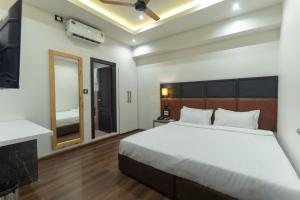 a bedroom with a large bed and a mirror at Grand Hotel Annex in Āīzawl